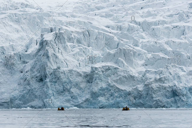 Tourists on inflatable boats exploring Polar Ice cap, north of Spitsbergen, Norway