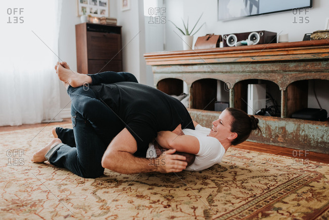 Couple wrestling on carpet at home