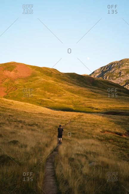 Girl hiking alone during sunset in the countryside