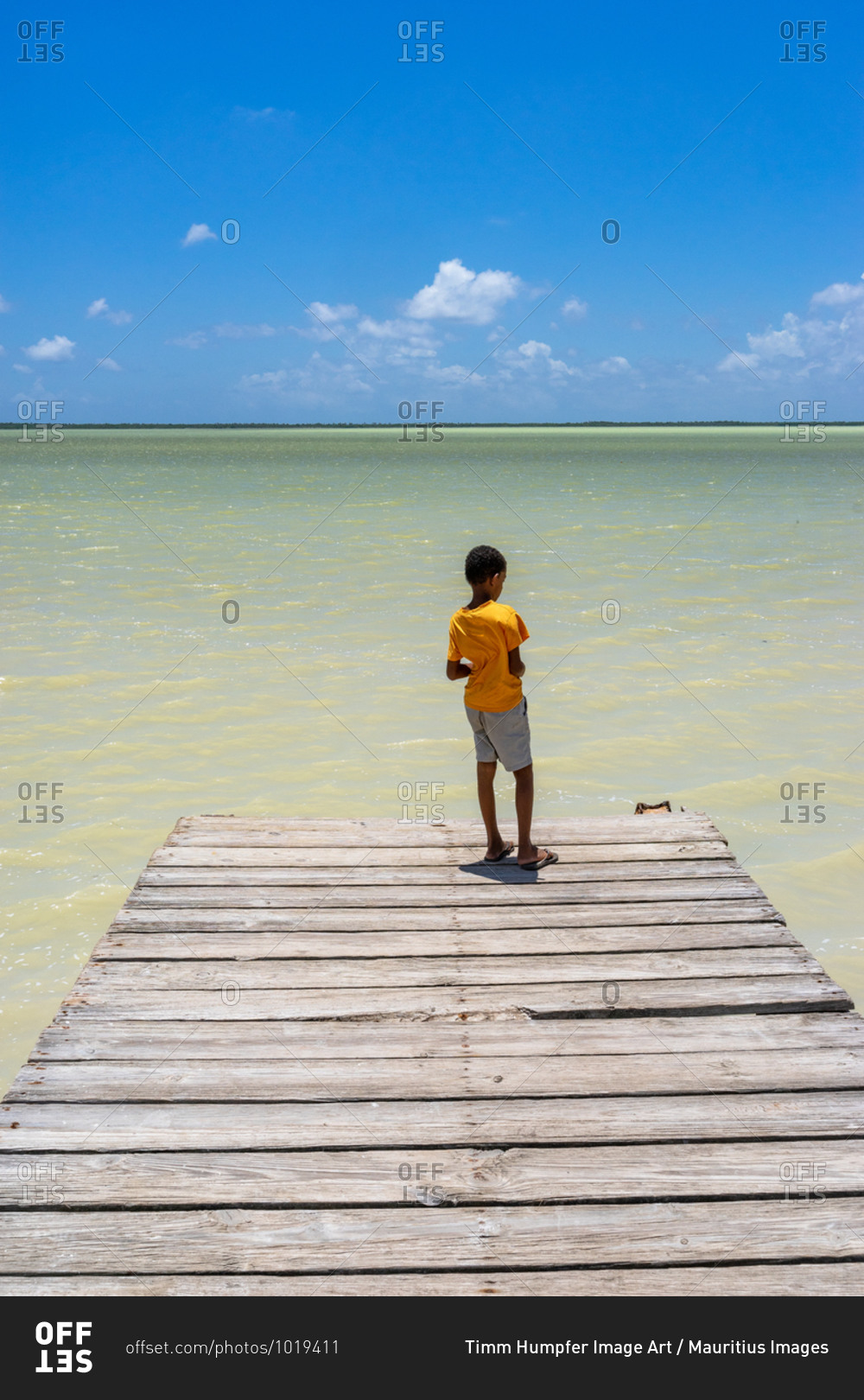 America, Caribbean, Greater Antilles, Dominican Republic, Oviedo, Laguna de Oviedo, boy stands on the jetty at the Laguna de Oviedo salt water lake