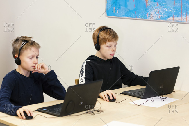 Boys in classroom using laptops