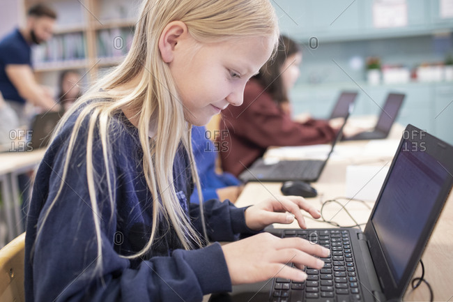 Girl in classroom using laptop
