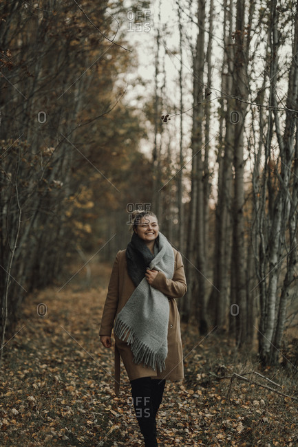 Woman walking through autumn forest
