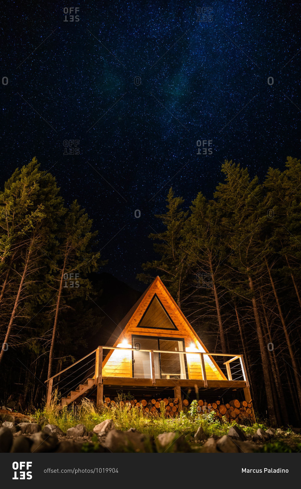 An a-frame cabin in the mountains at night