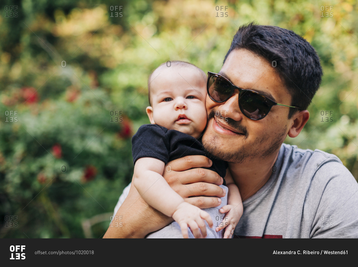 Loving man carrying cute son at park during weekend
