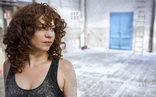 Redhead woman with white dust stains on face looking away