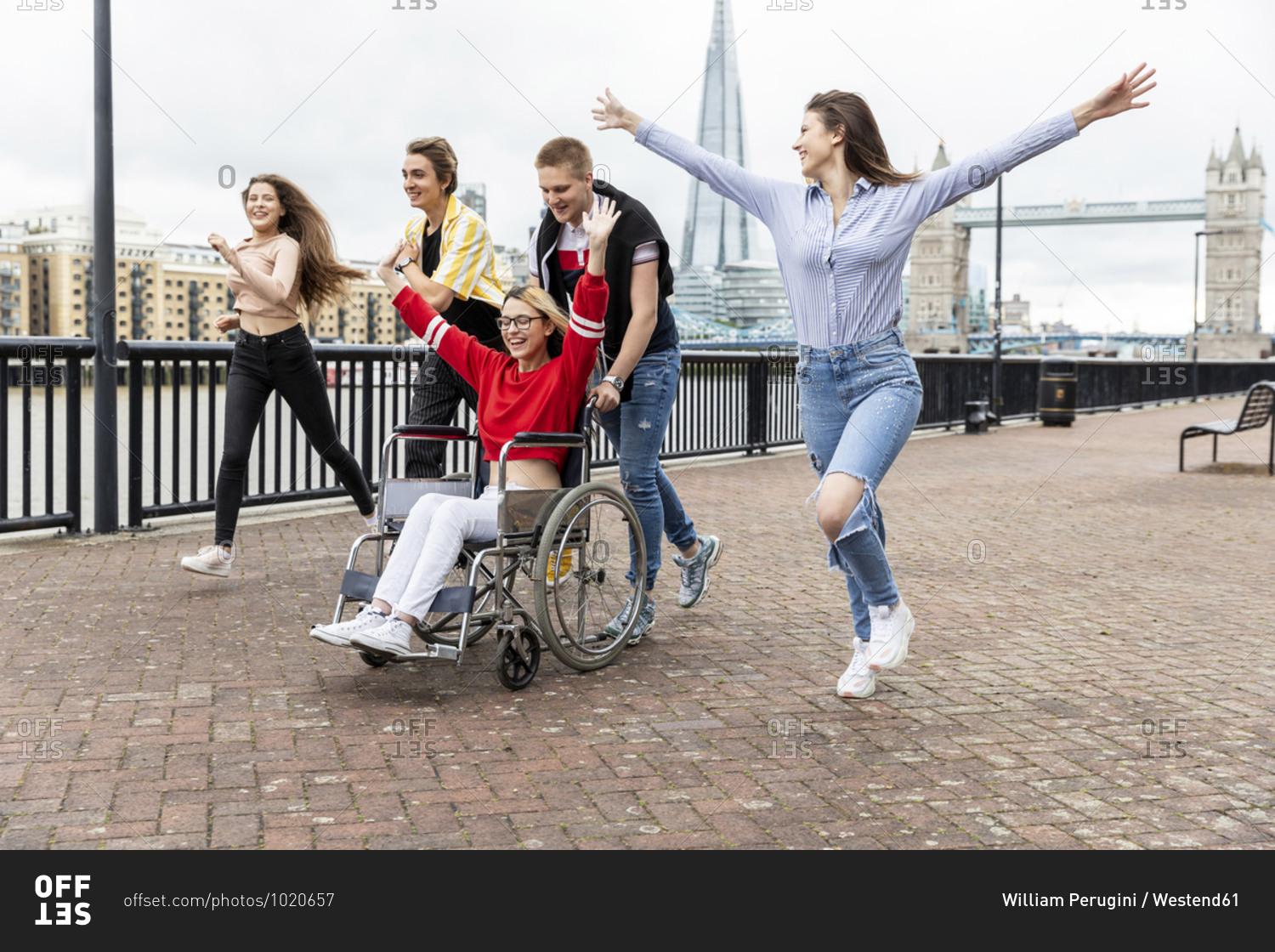 Carefree men and women with disabled female friend spending leisure time in city- London- UK