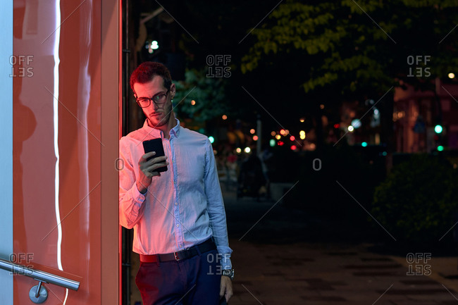Young businessman looks at his phone at night. entrepreneur, bus