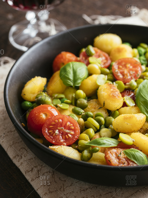 Roasted gnocchi with field beans, peas and tomaotes
