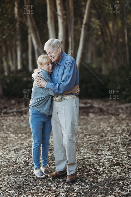 Portrait of senior retired adult couple embracing in forest