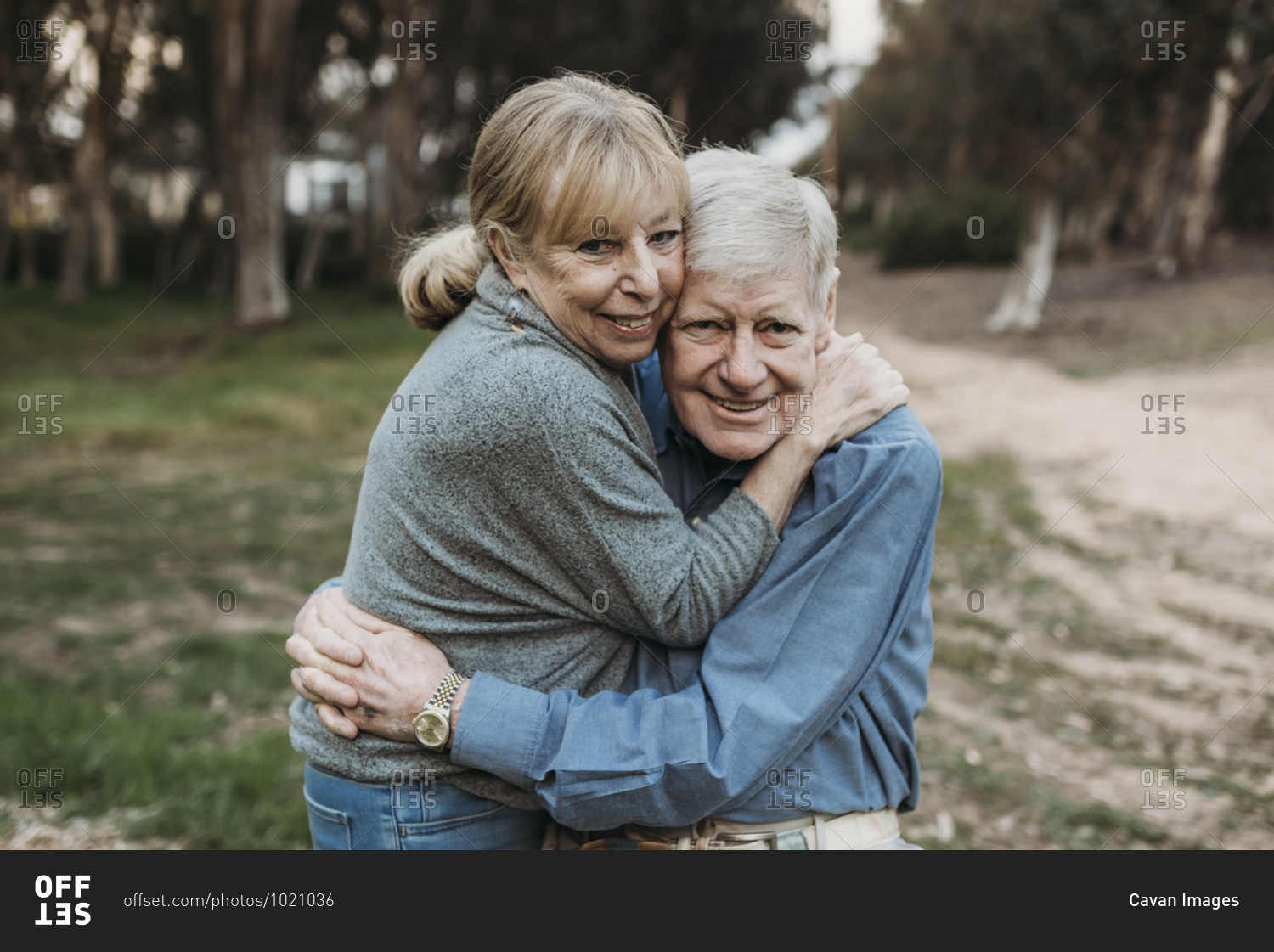 Close up portrait of senior adult couple hugging in forest
