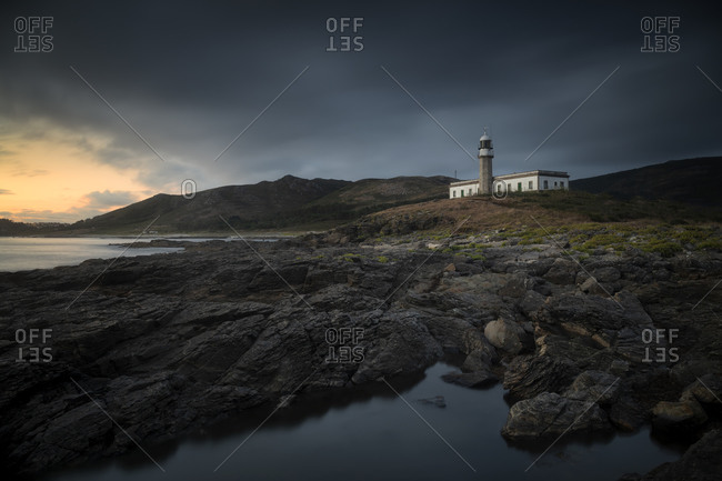 Lonely lighthouse on the coast at sunset