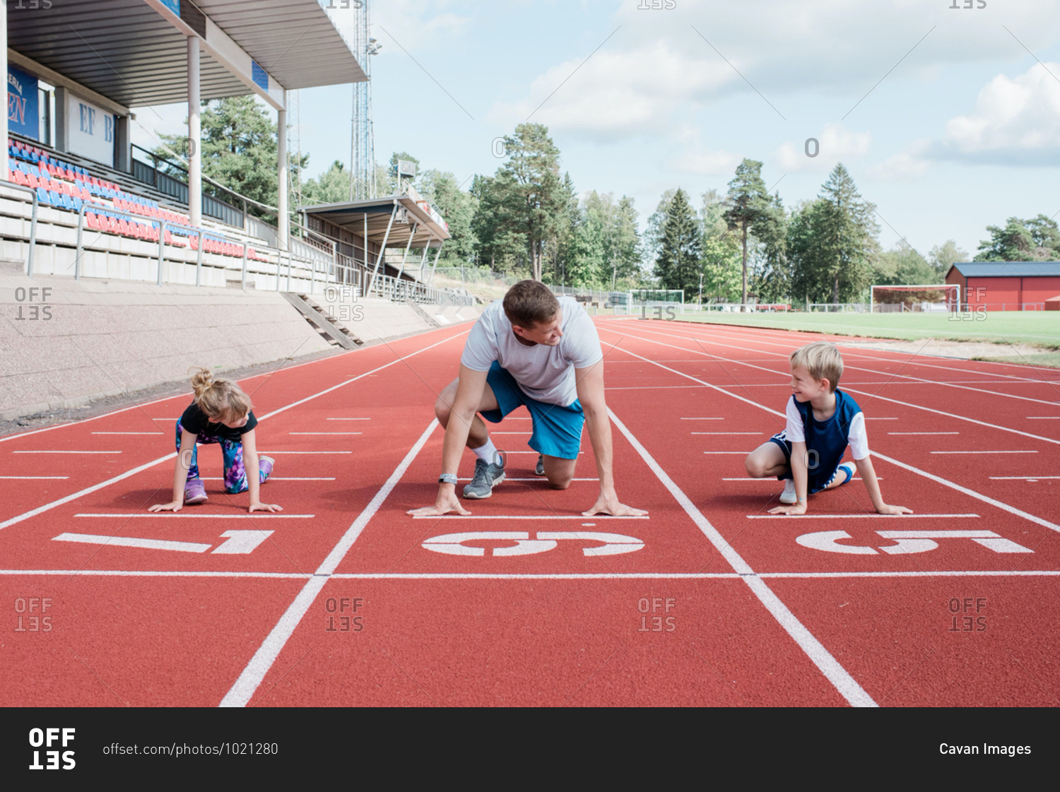 Father and his kids getting ready to run on a track to race
