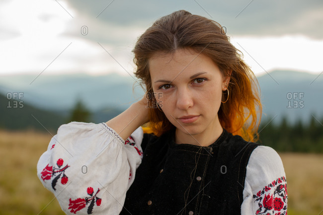 Portrait of a girl in embroidery in the mountains