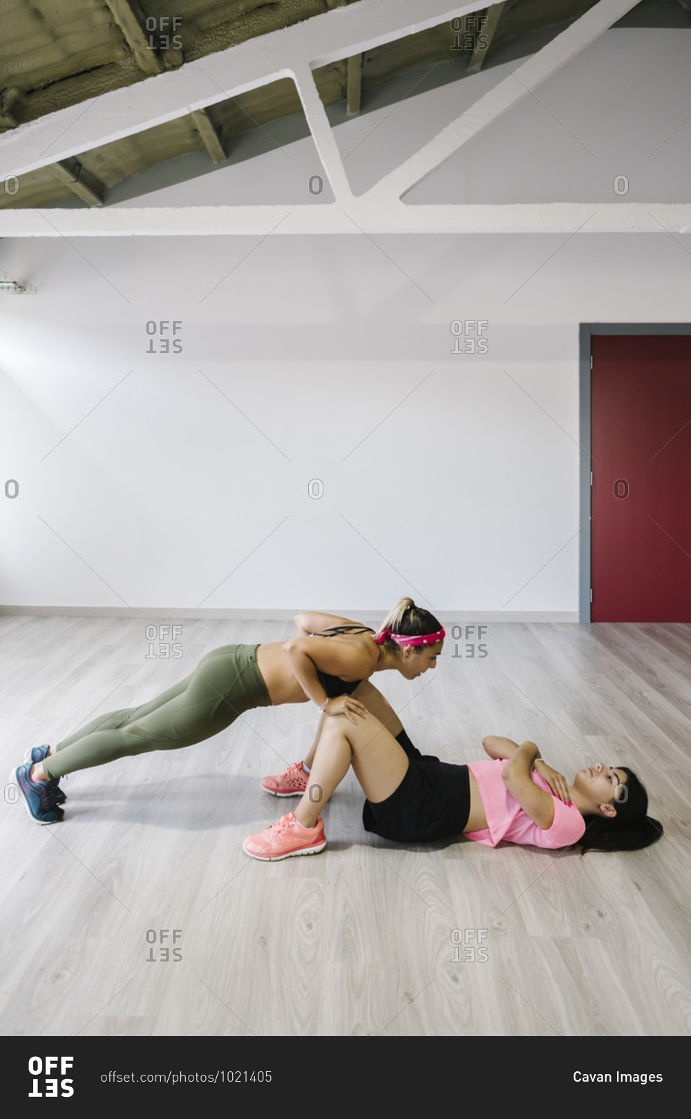 Young girl training in gym with her personal trainer