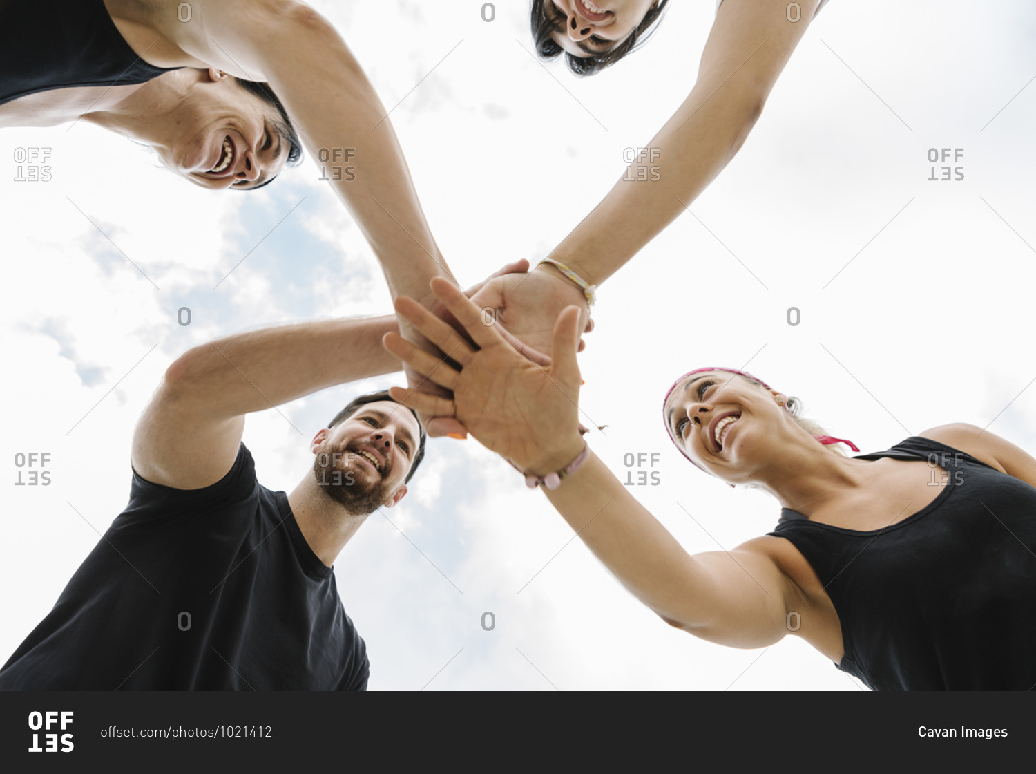 Bottom view of a group of people motivated by their personal trainer outdoors