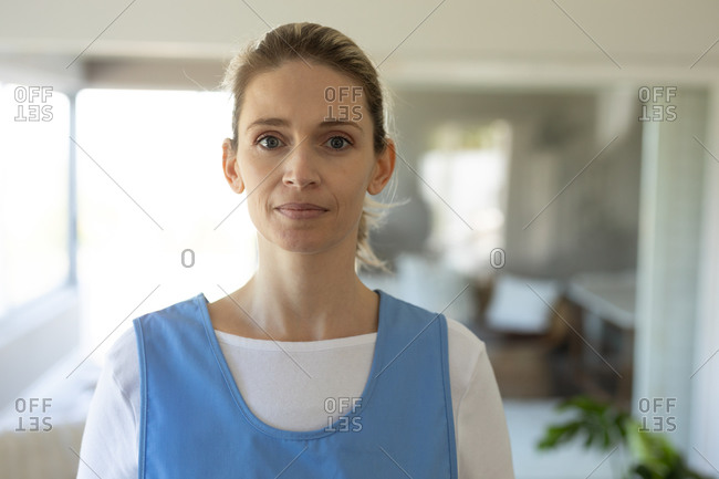 Portrait of Caucasian female nurse,
looking at the camera and smiling. Medical care
at home during Covid 19 Coronavirus quarantine.