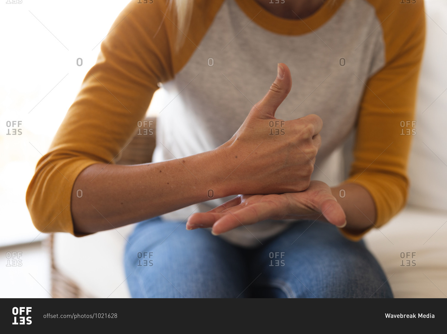 Caucasian woman spending time at home, sitting on a sofa, using sign language. Social distancing during Covid 19 Coronavirus quarantine lockdown.