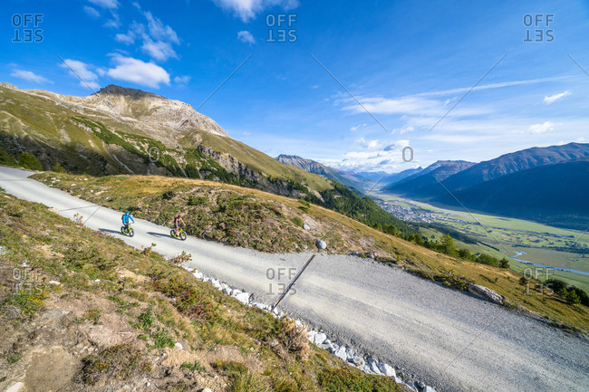 Elevated view of tourists riding downhill scooters on mountain path, Celerina, Engadine, canton of Graubunden, Switzerland, Europe