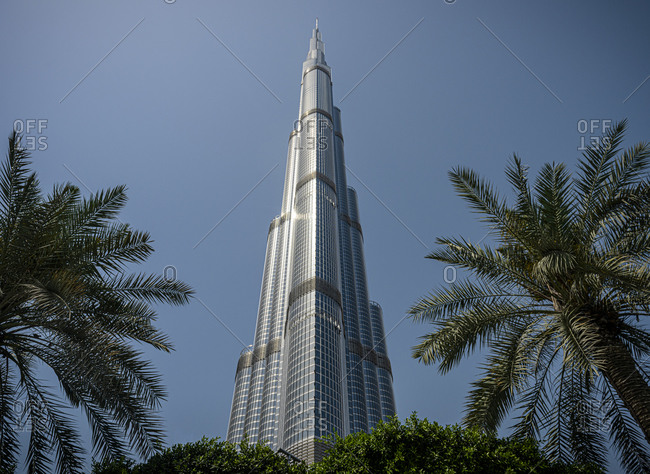 Dubai, United Arab Emirates - April 5, 2018: The Burj Khalifa skyscraper in Dubai seen through palm tree leaves