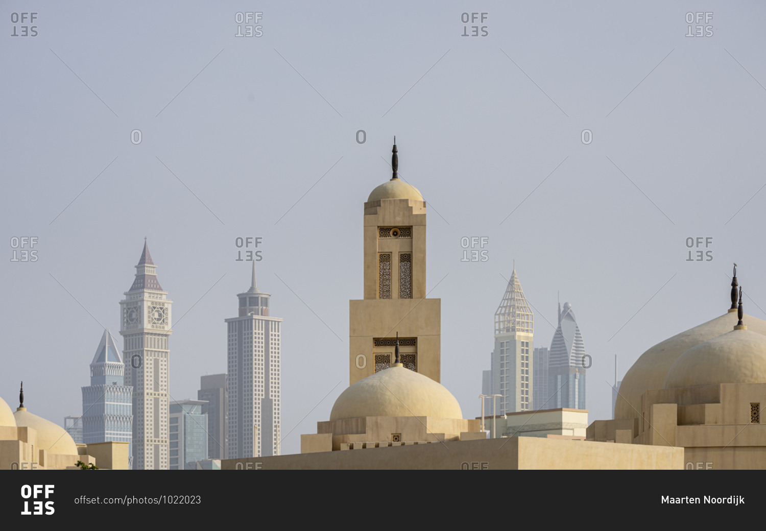 Domes of a mosque with skyscrapers in the background in the business district of Dubai, United Arab Emirates
