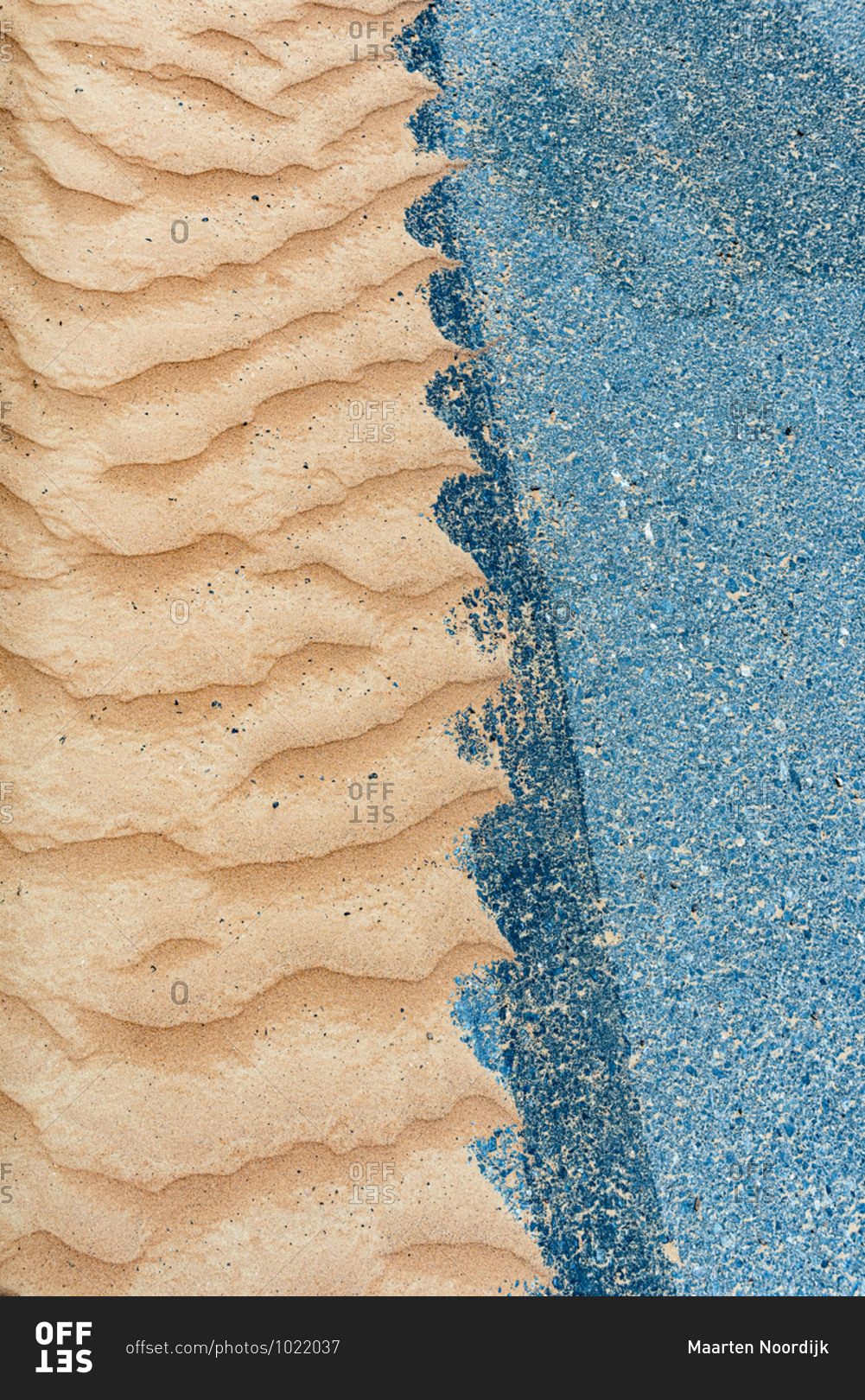 Desert sand and a concrete road meet on the edge of the desert in United Arab Emirates