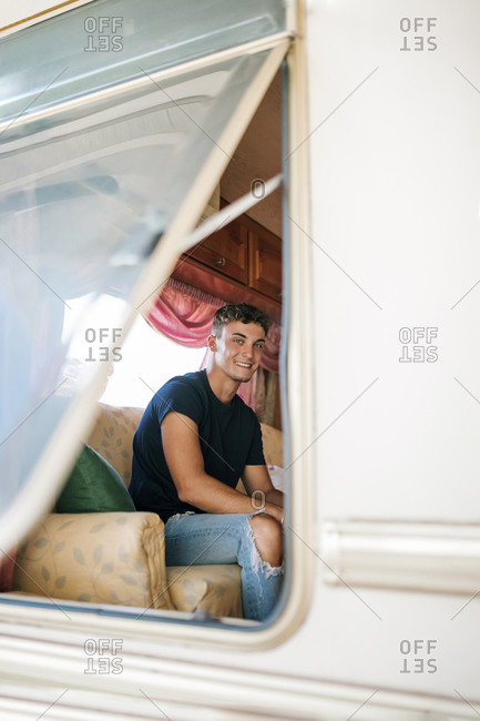 Portrait of young blond boy inside a caravan