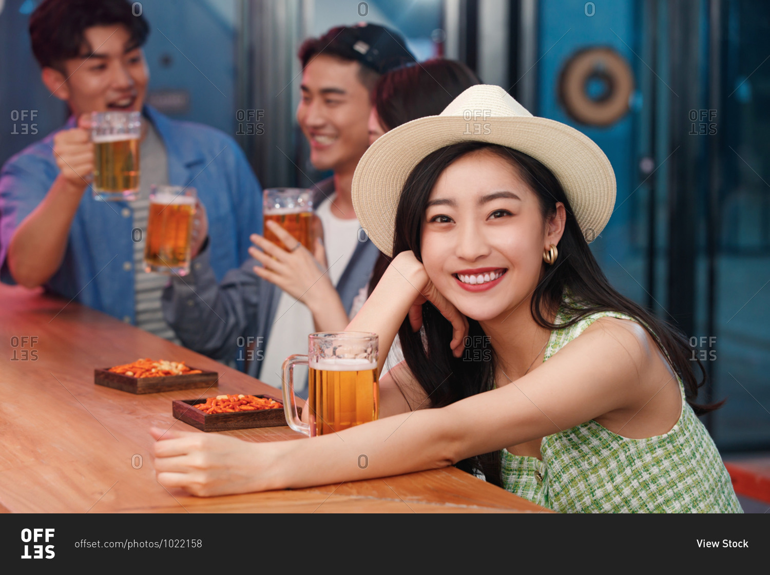 Young women drinking with friends in a bar