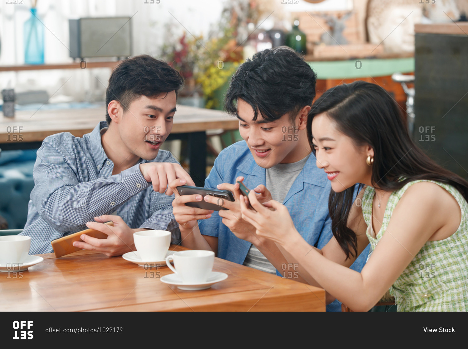 Young friends in a cafe to play mobile phone