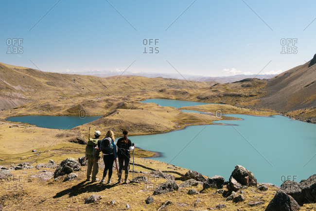 Hikers looking at lake, Ausangate, Willkanuta mountain range, Andes, Peru