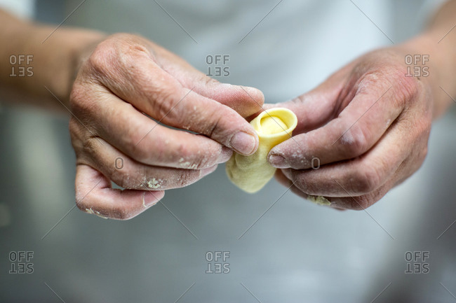 Close up of male pasta makers hands shaping pasta, Cagliari, Sardinia, Italy