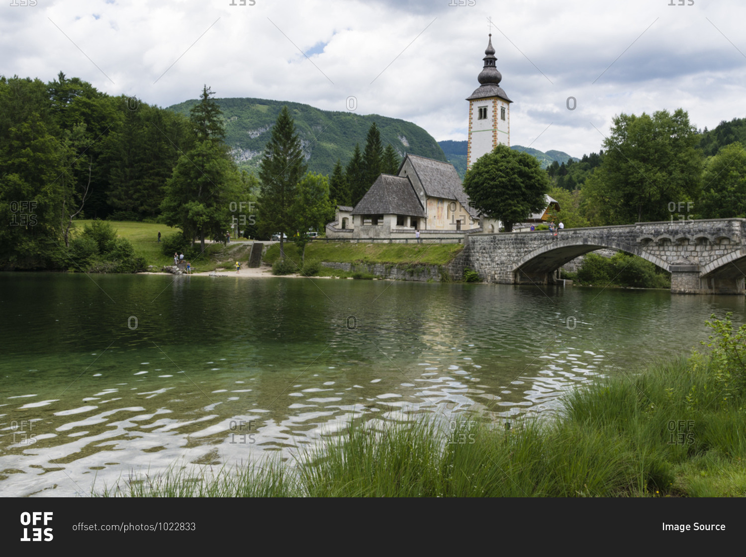 Church of St John the Baptist and the stone bridge over lake Bohinj, Slovenia