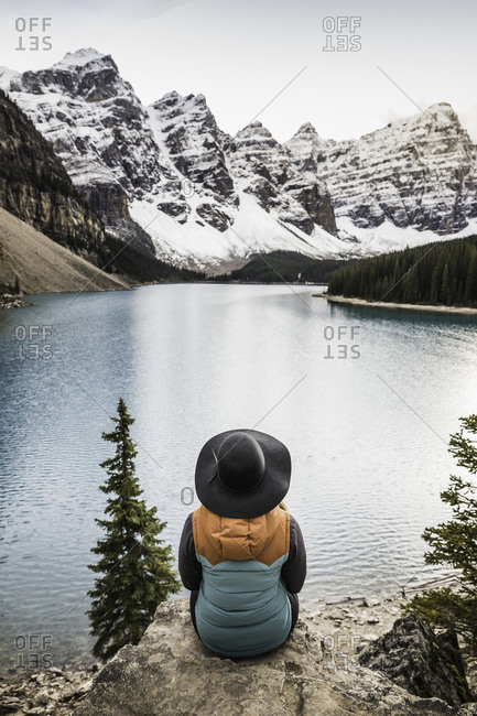 Woman sitting, looking at view, Moraine Lake, Lake Louise, Alberta, Canada
