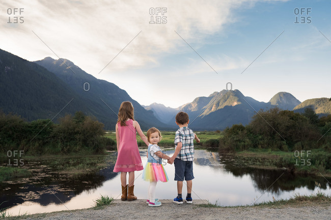 Siblings standing by Pitt Lake in British Columbia, Canada