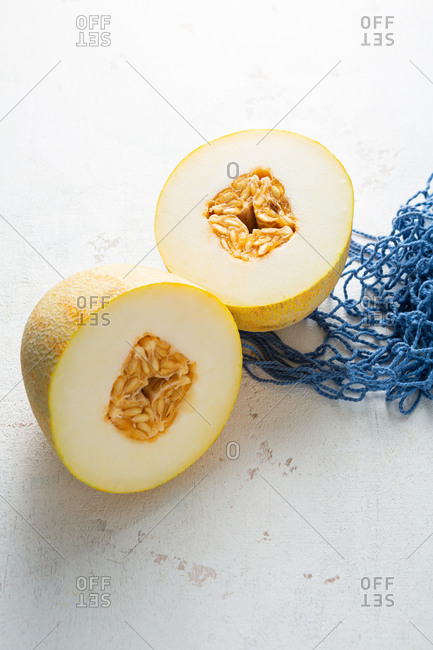 Two slices of ripe melon on light surface