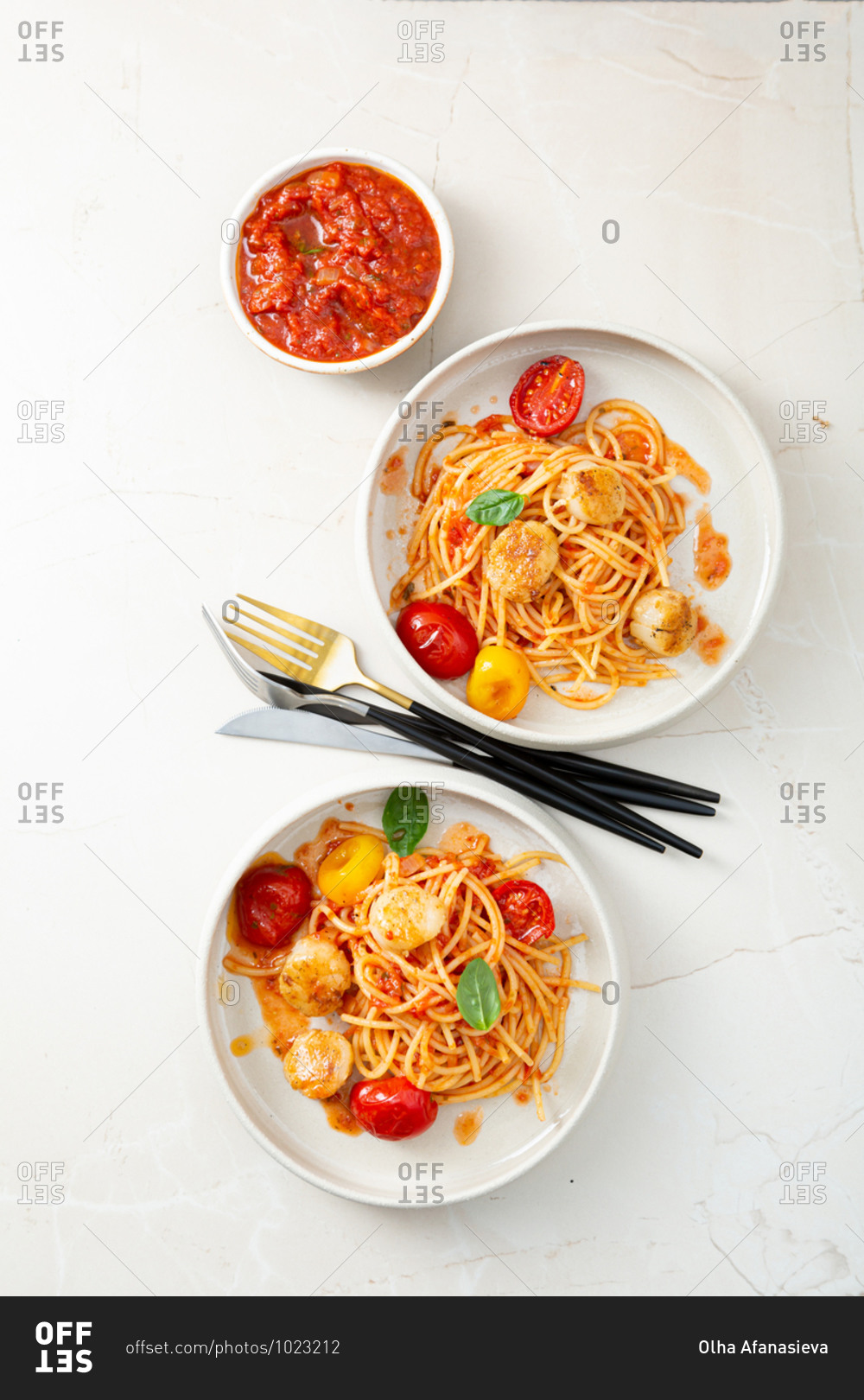 Overhead view of pasta with scallops and red sauce