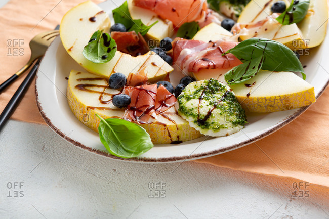 Close up of summer melon and prosciutto salad on a platter