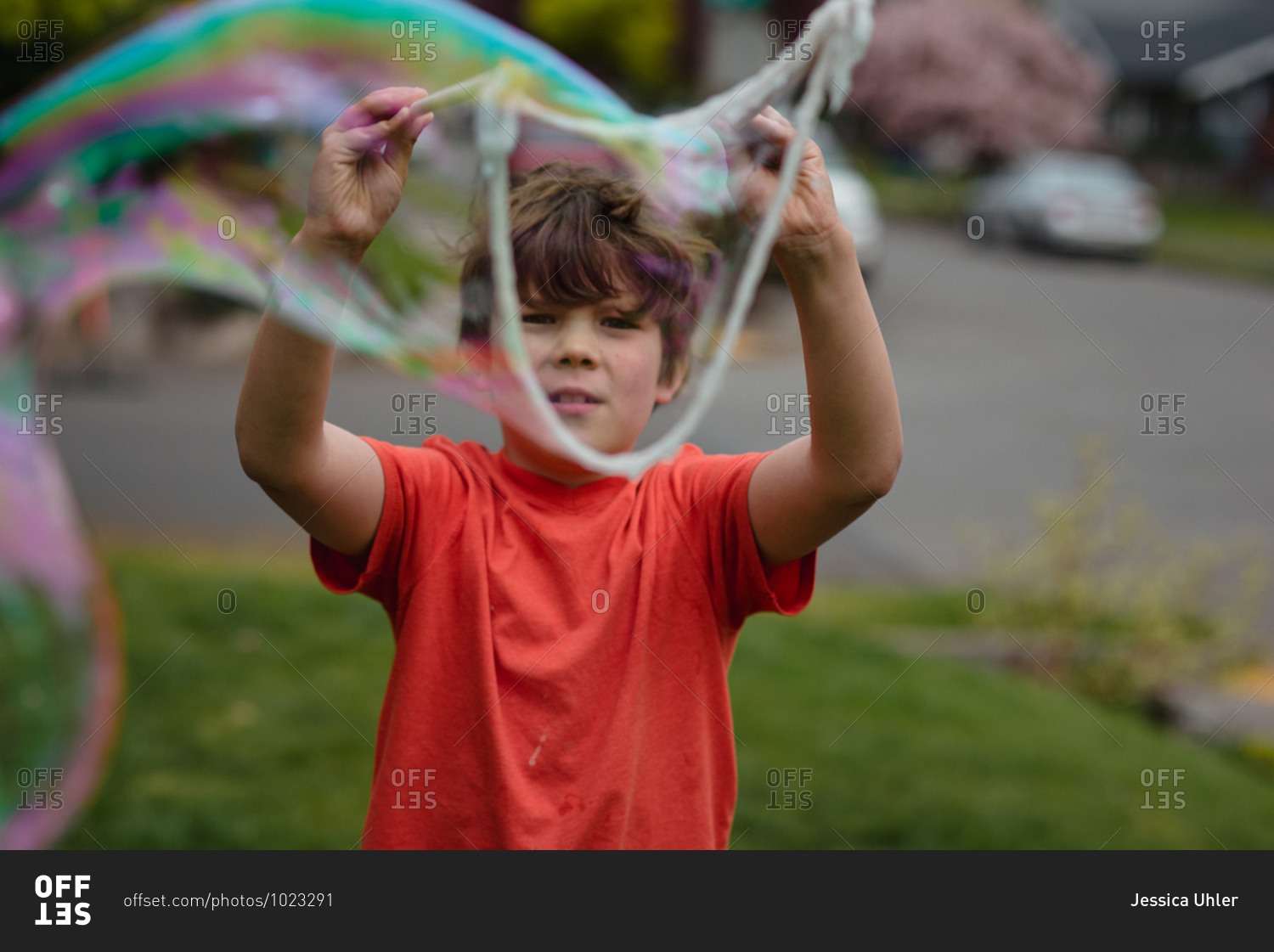 Boy playing with a large bubble wand