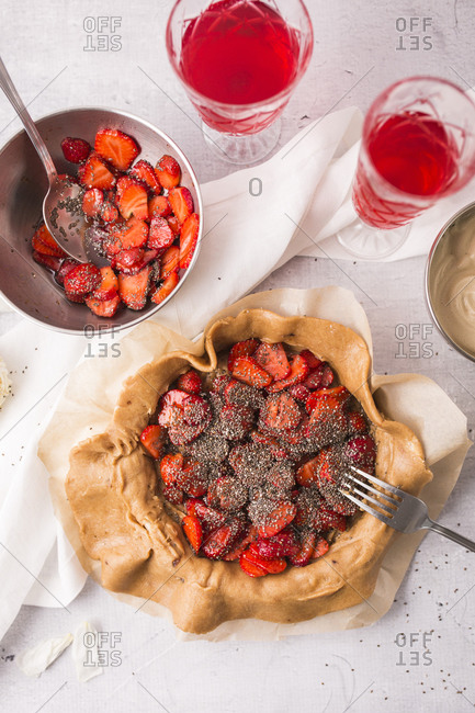 Strawberry galette with vanilla bean and chia seeds being prepared on light surface