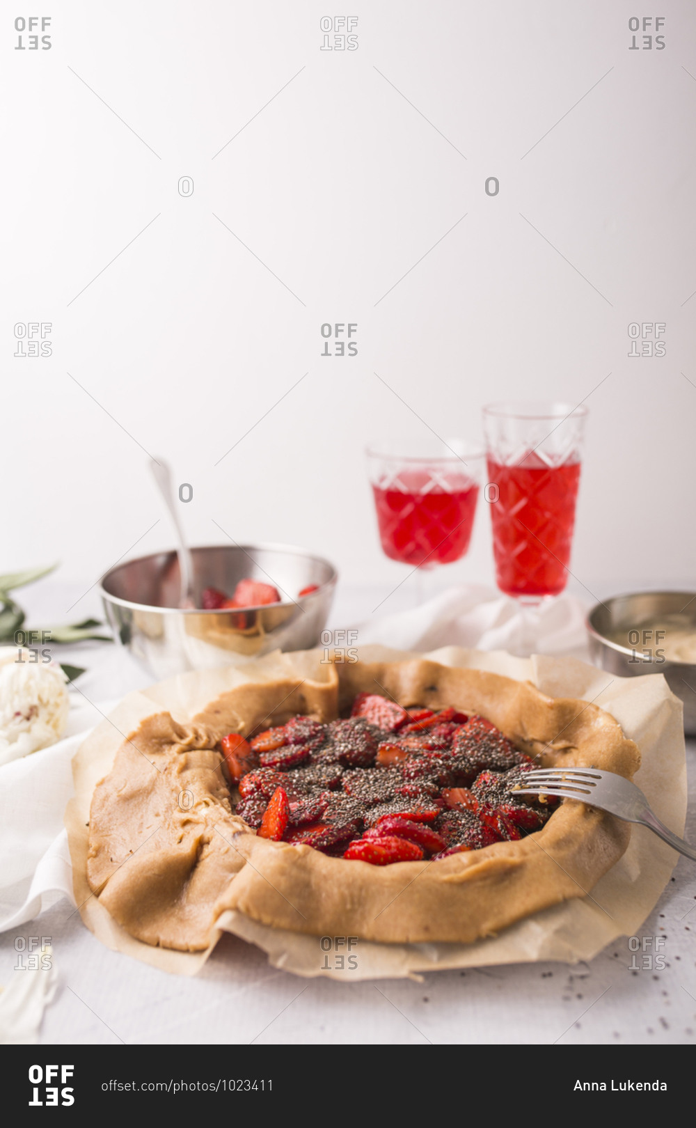 A strawberry galette with vanilla bean and chia seeds in progress with copy space