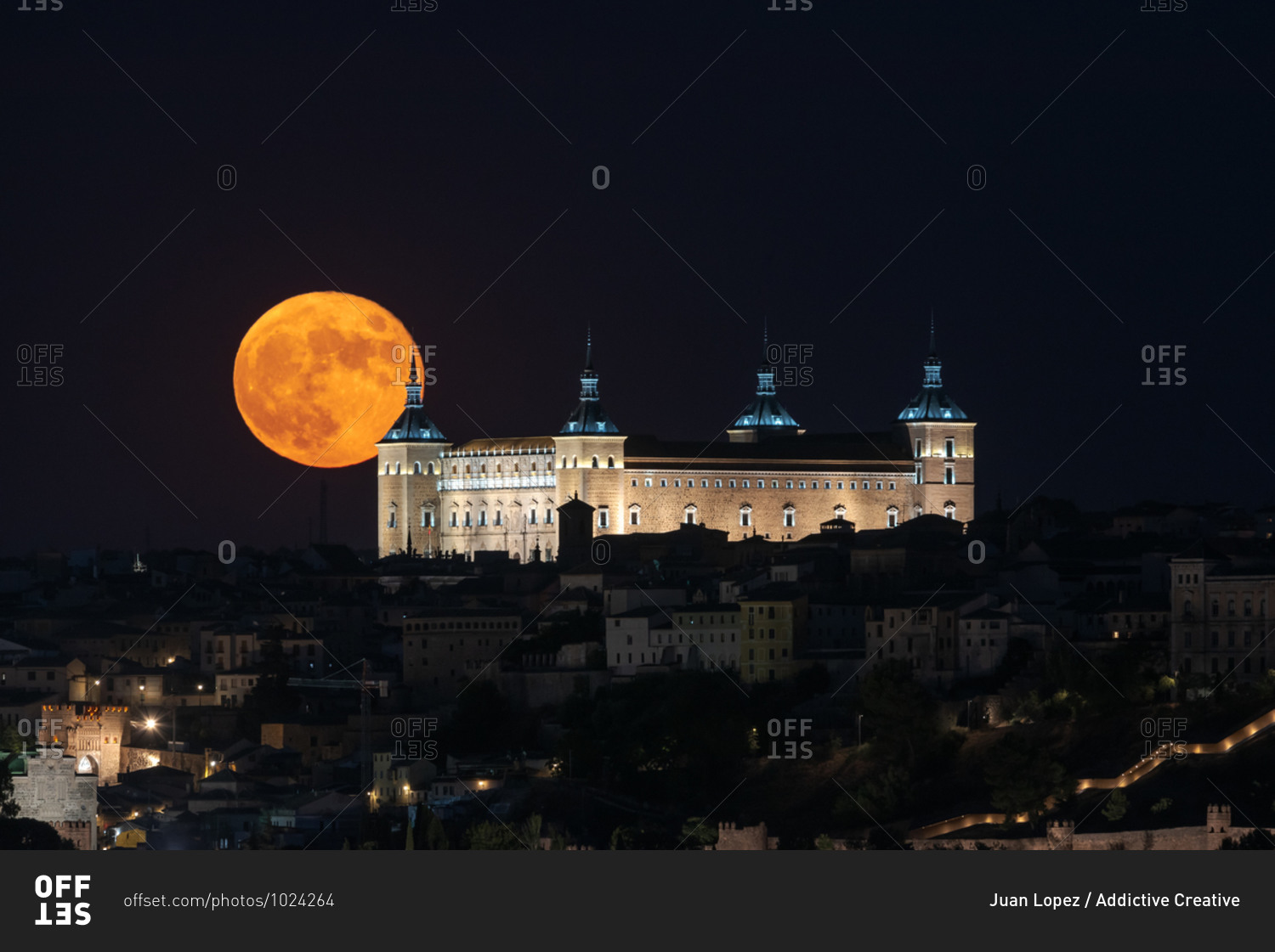 Amazing view of bright full moon in dark night sky over old town with glowing historical palace
