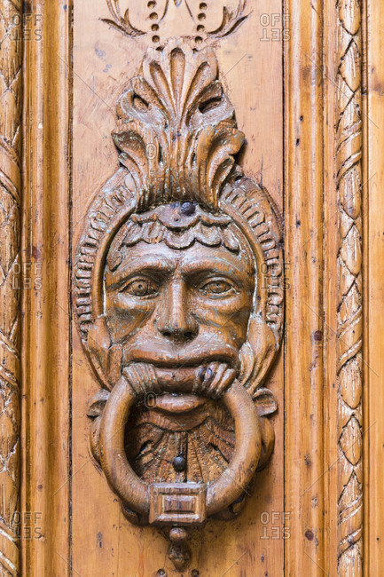 Doorknocker showing a human face in a wooden door, Barri Gotic, Old City, Barcelona, Catalonia, Spain