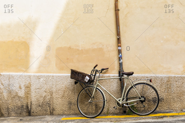 Bicycle with a front basket by a wall and yellow line on the ground, Old City, Palma de Mallorca, Mallorca, Balearic Islands, Spain