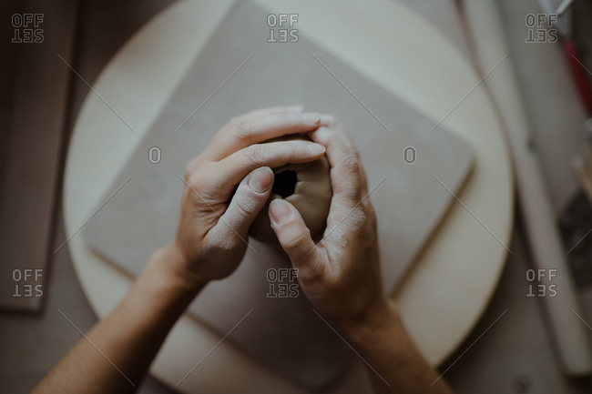 Overhead view of the hands of woman molding clay