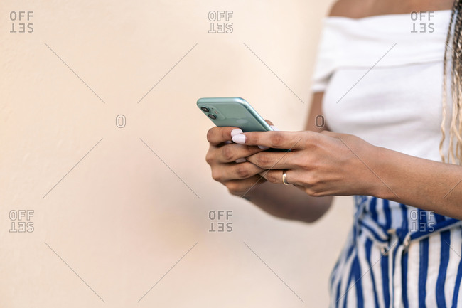 Unrecognized young woman using phone in the street