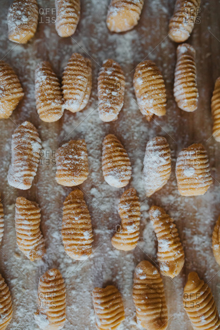 Detail of freshly rolled sweet potato gnocchi on a floured wooden cutting board