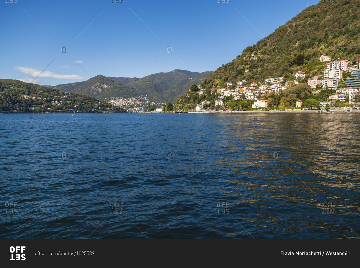 Town at lakeshore of Lake Como against sky on sunny day