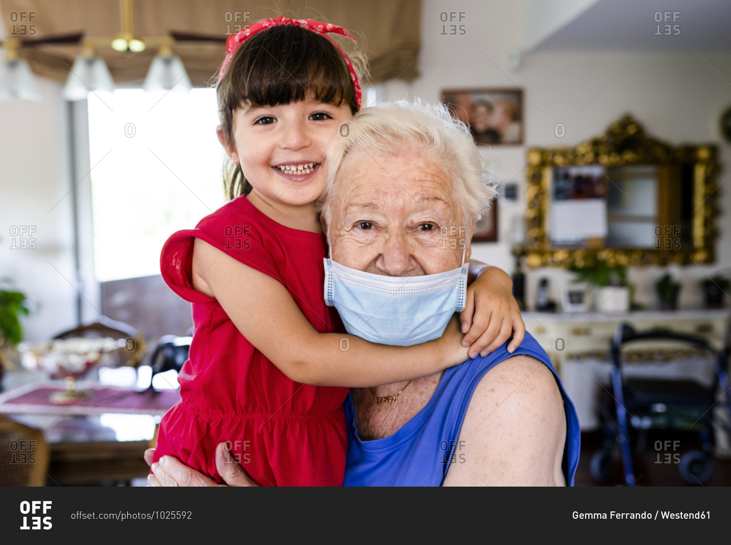 Grandmother and little girl spending family time together at home- with face mask