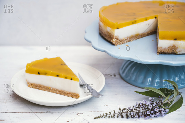 Slice of layered tart with crumble crust- coconut milk- custard and passion fruit top
