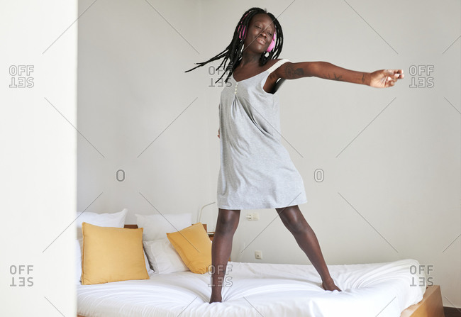 Young blonde woman sitting on a pillow stock photo - OFFSET